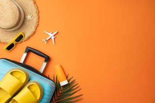 Colorful suitcase with hat sunglasses yellow shoes toy plane sunscreen