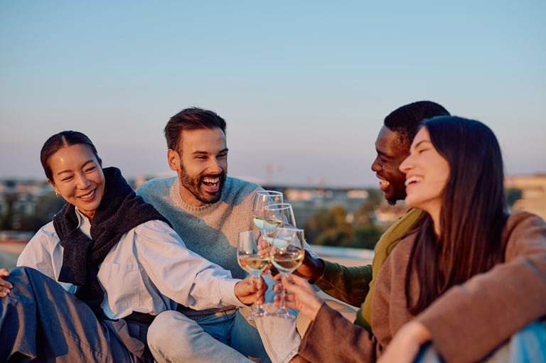 Diverse friends celebrating on rooftop at sunset